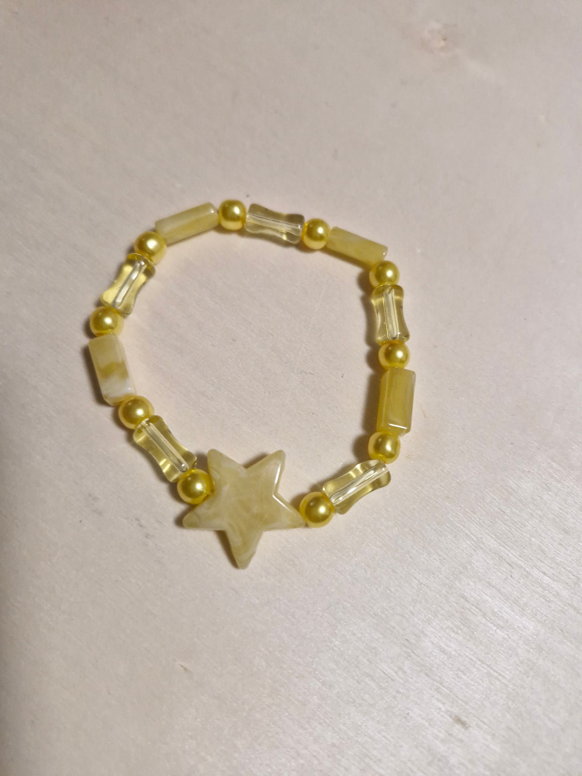 Handmade triple strand yellow crystal and pearl necklace with butterfly charms and heart pendant on bust display